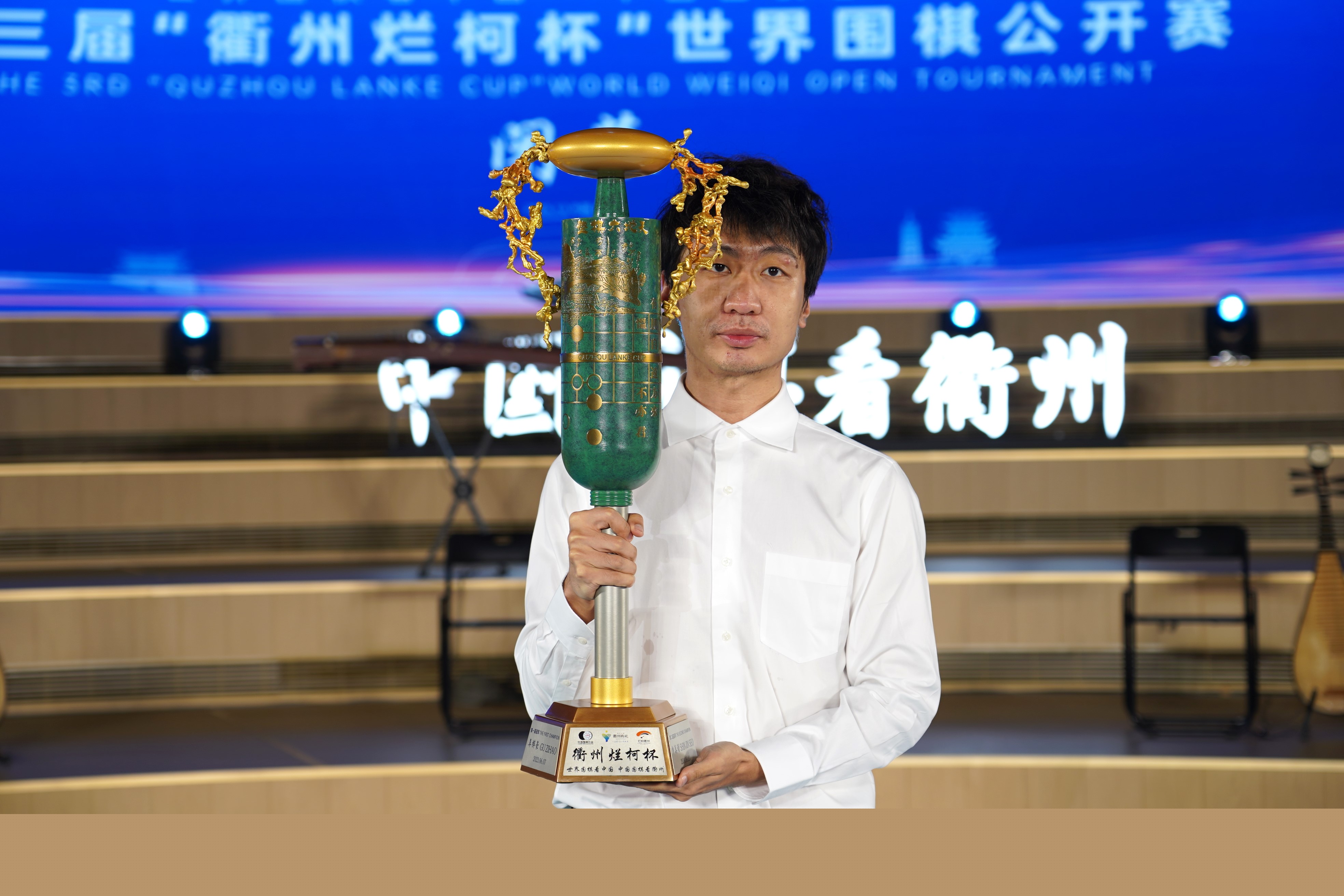 党毅飞捧起冠军奖杯。中国围棋协会供图