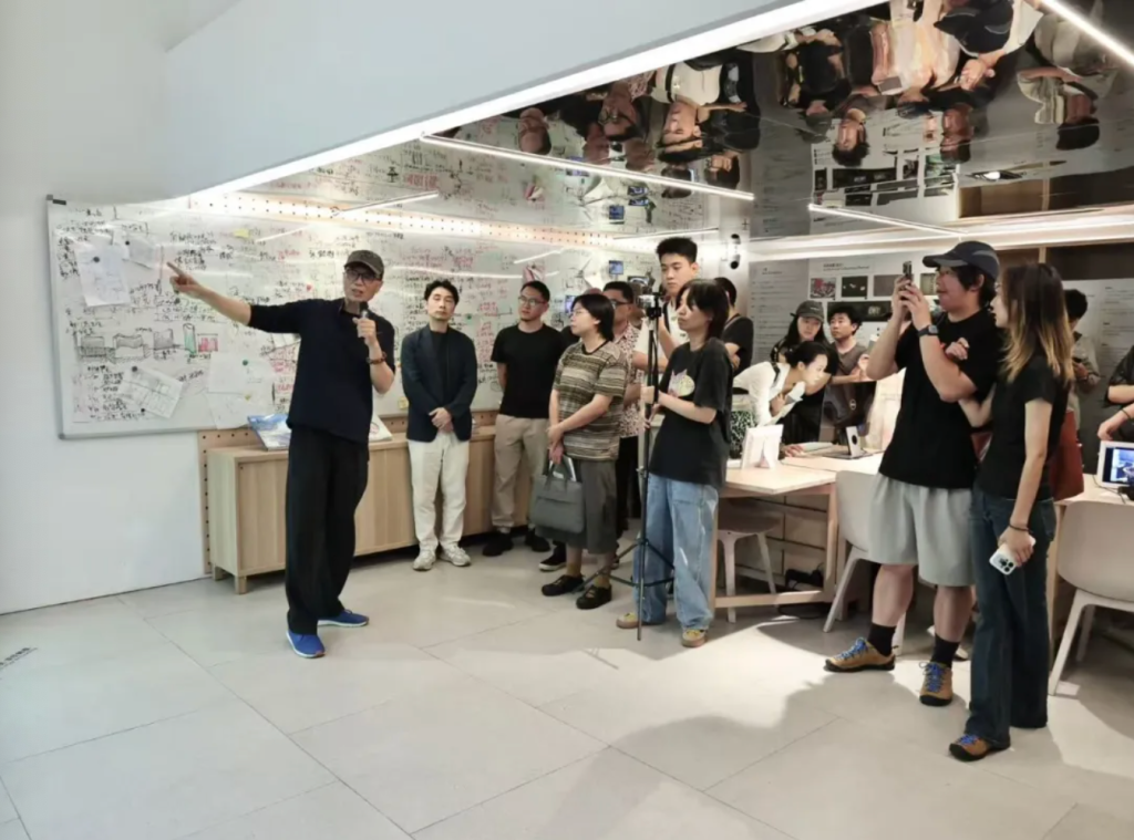 展览开幕现场，艺术家胡介鸣向观众介绍数字档案资料